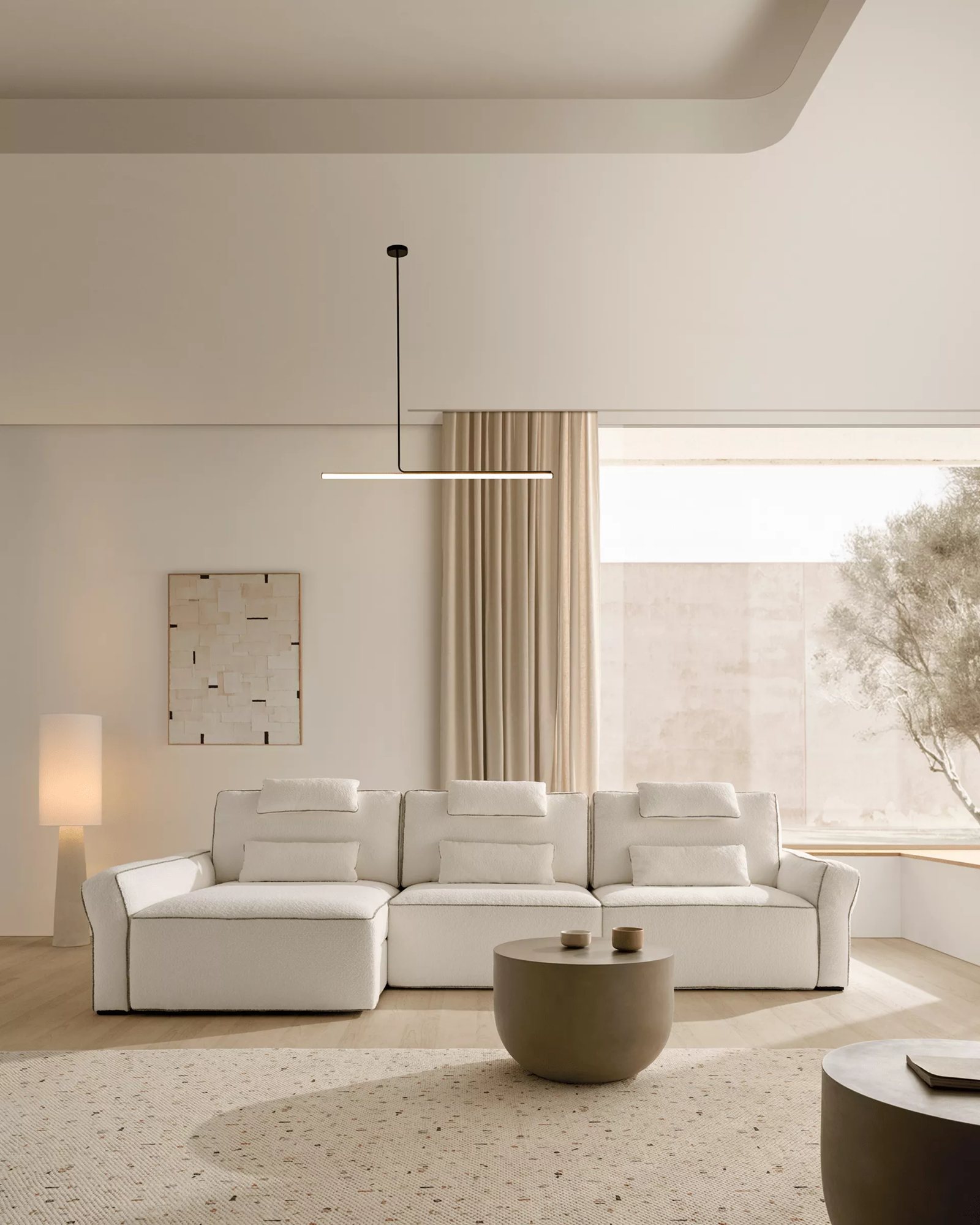 Canapé Acomodel en tissu bouclé crème dans un salon lumineux et épuré